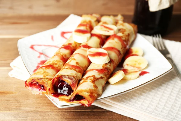 Assiette de délicieuses crêpes avec confiture de baies sur fond en bois — Photo