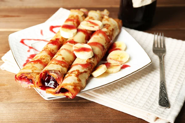 Piatto di deliziose frittelle con marmellata di bacche su sfondo di legno — Foto Stock