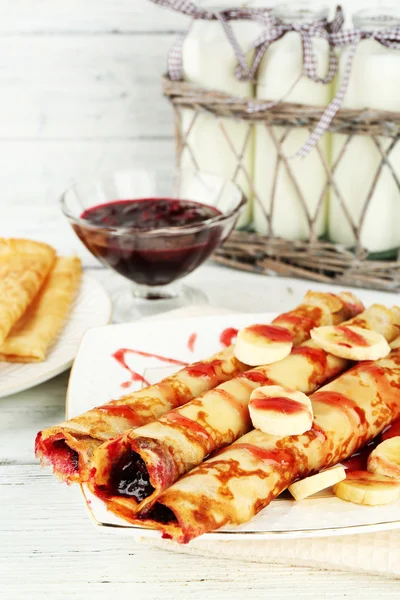 Placa de deliciosos panqueques con mermelada de bayas sobre fondo de madera — Foto de Stock