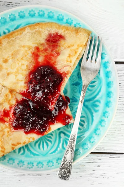 Placa de deliciosos panqueques con mermelada de bayas sobre fondo de madera — Foto de Stock