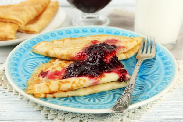 Plaat van heerlijke pannenkoeken met berry jam op houten achtergrond — Stockfoto