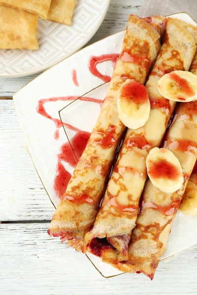 Placa de deliciosos panqueques con mermelada de bayas sobre fondo de madera — Foto de Stock