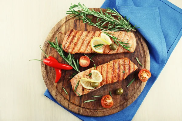 Grilled salmon with spices on cutting board on wooden background — Stock Photo, Image
