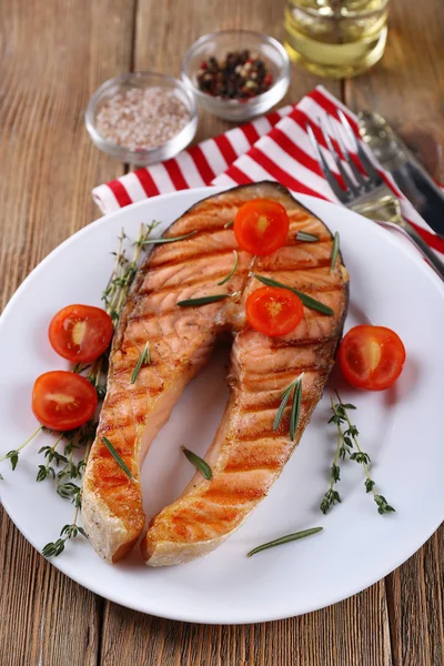 Гриль лосось и овощи на тарелке на деревянном фоне — стоковое фото