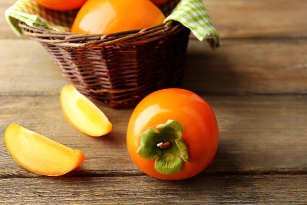 Ripe persimmons on wooden background — Stock Photo, Image