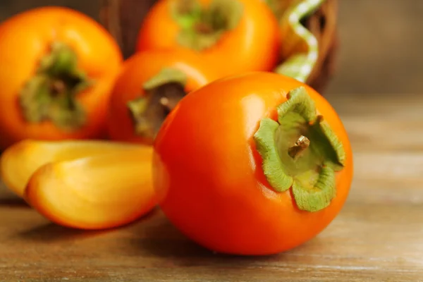 Ripe persimmons on wooden background — Stock Photo, Image