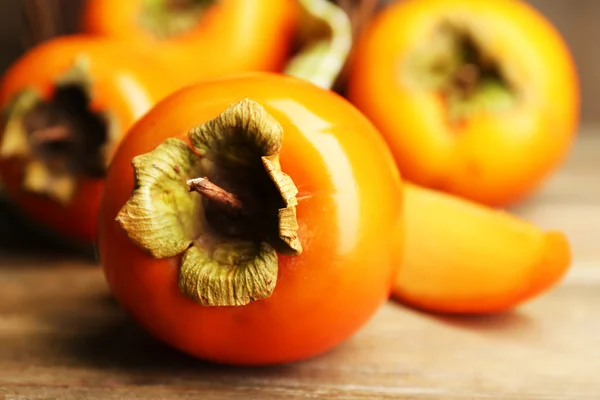 Coapte persimmons pe fundal din lemn — Fotografie, imagine de stoc