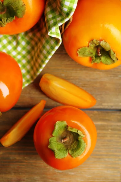 Rijpe persimmons op houten ondergrond — Stockfoto