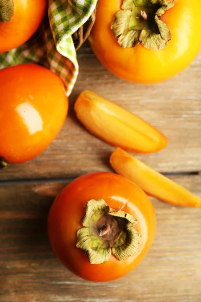 Ripe persimmons on wooden background — Stock Photo, Image