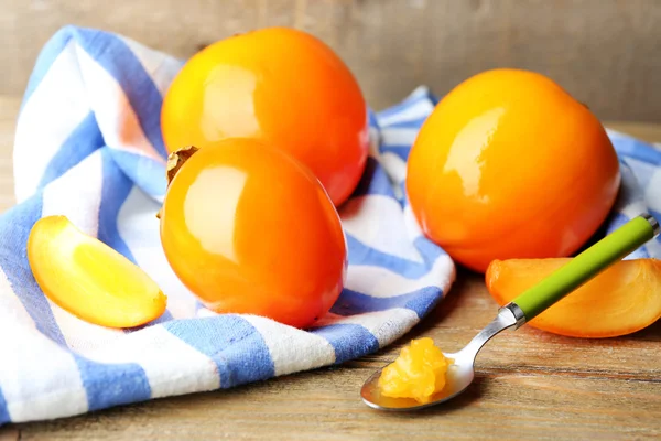 Ripe persimmons on wooden background — Stock Photo, Image