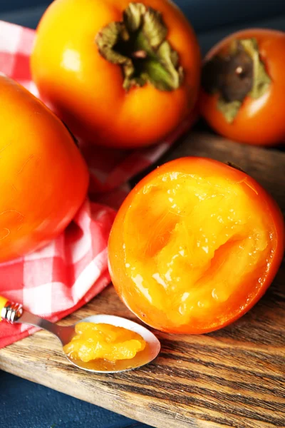 Ripe persimmons on cutting board,   close-up — Stock Photo, Image