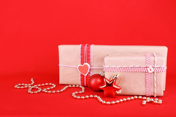 Hermosos regalos brillantes y decoración de Navidad sobre fondo rojo —  Fotos de Stock