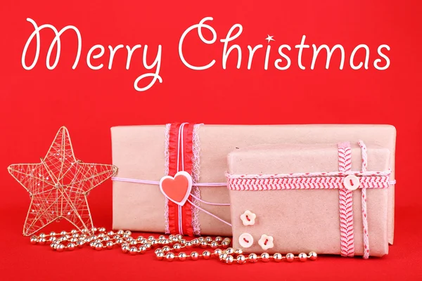 Hermosos regalos brillantes y decoración de Navidad sobre fondo rojo —  Fotos de Stock