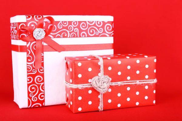 Hermosos regalos brillantes y decoración de Navidad sobre fondo rojo —  Fotos de Stock