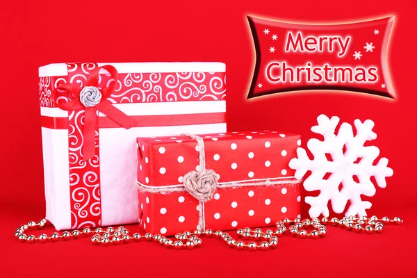 Beautiful bright gifts and Christmas decoration on red background — Stock Photo, Image