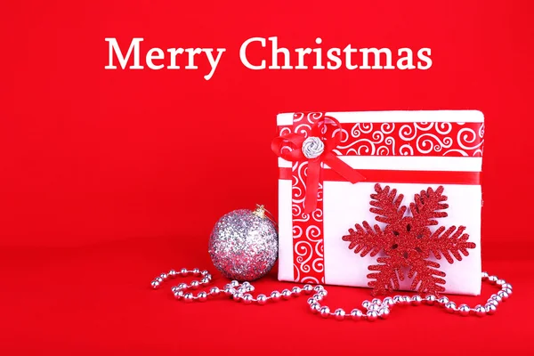 Όμορφο φωτεινό δώρο και Χριστουγεννιάτικη διακόσμηση σε κόκκινο φόντο — Φωτογραφία Αρχείου