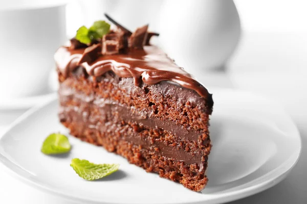 Delicious chocolate cake on plate on table on light background — Stok Foto