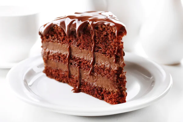 Delicious chocolate cake on plate on table on light background — Stock Photo, Image