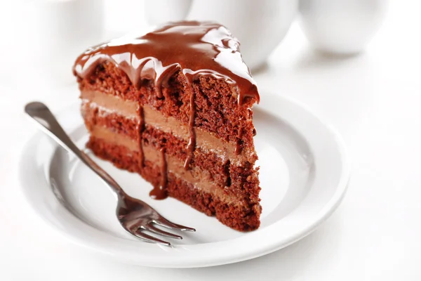 Deliziosa torta al cioccolato sul piatto sul tavolo su sfondo chiaro — Foto Stock