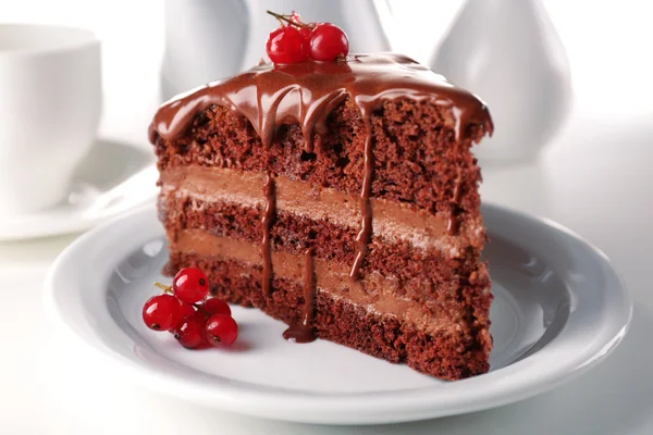 Delicious chocolate cake on plate on table on light background — Stock Photo, Image