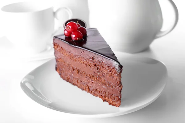 Delicioso bolo de chocolate na placa na mesa no fundo claro — Fotografia de Stock