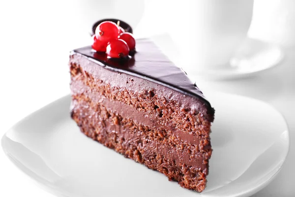 Deliziosa torta al cioccolato sul piatto sul tavolo su sfondo chiaro — Foto Stock