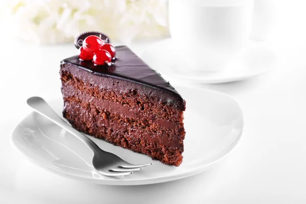 Délicieux gâteau au chocolat sur plaque sur table sur fond clair — Photo