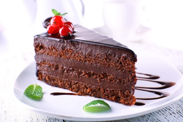 Νόστιμο κέικ σοκολάτας στο πιάτο στο τραπέζι στο φως φόντο — Φωτογραφία Αρχείου