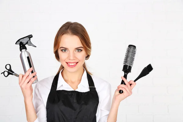 Beautiful girl hairdresser on light background — Stock Photo, Image