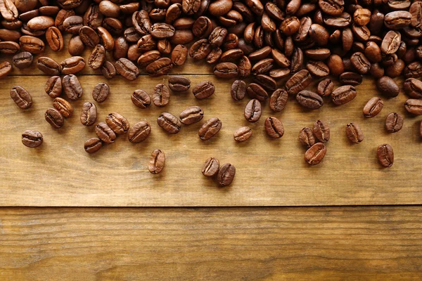 Grãos de café em fundo de madeira, close-up — Fotografia de Stock