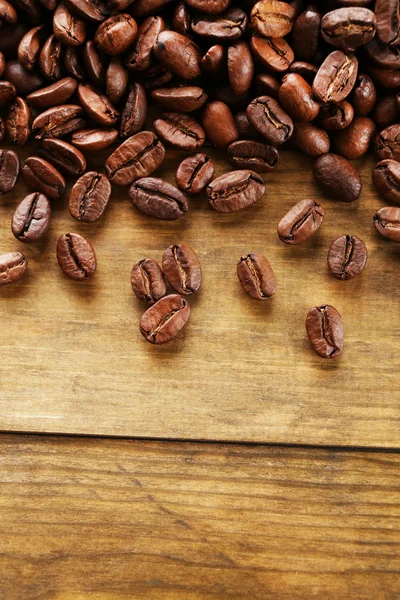 Grãos de café em fundo de madeira, close-up — Fotografia de Stock