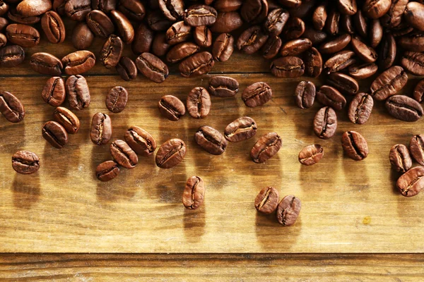 Grãos de café em fundo de madeira, close-up — Fotografia de Stock