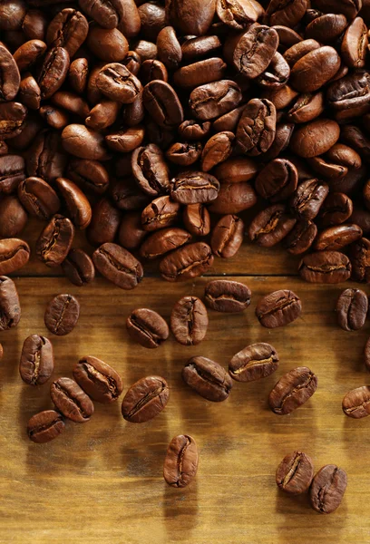 Grãos de café em fundo de madeira, close-up — Fotografia de Stock