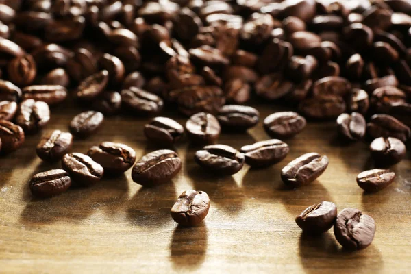 Grãos de café em fundo de madeira, close-up — Fotografia de Stock