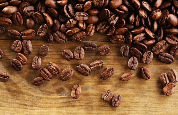 Kaffebönor på trä bakgrund, närbild — Stockfoto