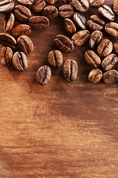 Chicchi di caffè su sfondo di legno, primo piano — Foto Stock