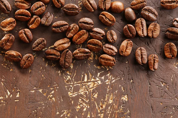 Kávová zrna na dřevěné pozadí, detail — Stock fotografie