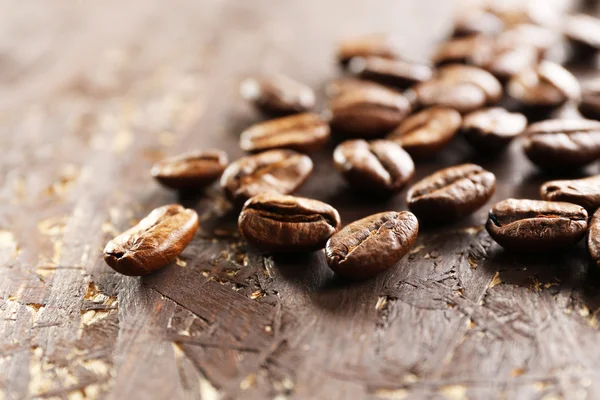 Granos de café sobre fondo de madera, primer plano —  Fotos de Stock