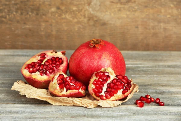 Beautiful composition with juicy  pomegranates, on old wooden table — Stock Photo, Image