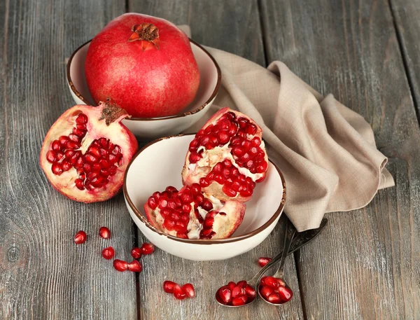 Beautiful composition with juicy  pomegranates, on old wooden table — Stock Photo, Image