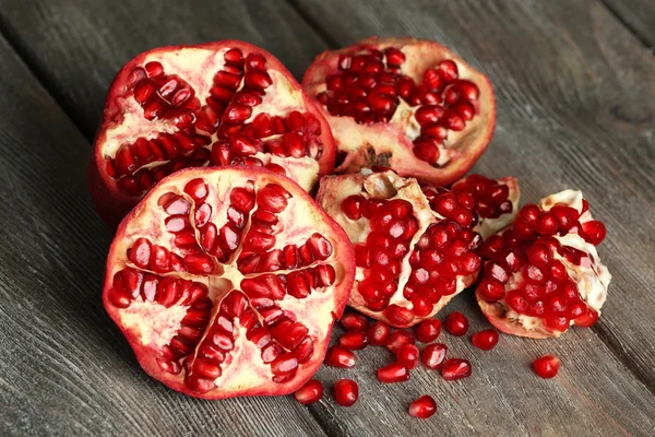 Beautiful composition with juicy  pomegranates, on old wooden table — Stock Photo, Image