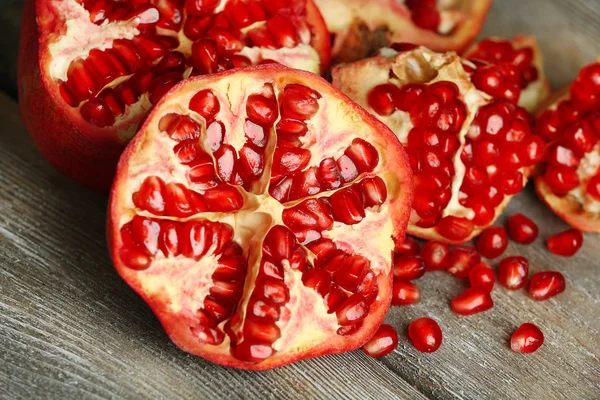 Beautiful composition with juicy  pomegranates, on old wooden table — Stock Photo, Image