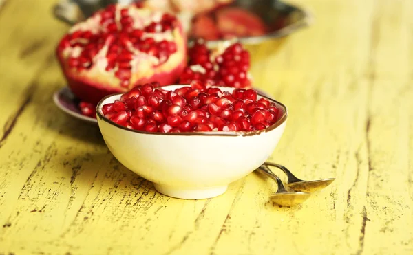 Mooie compositie met sappige granaatappel zaden, op gele houten tafel — Stockfoto