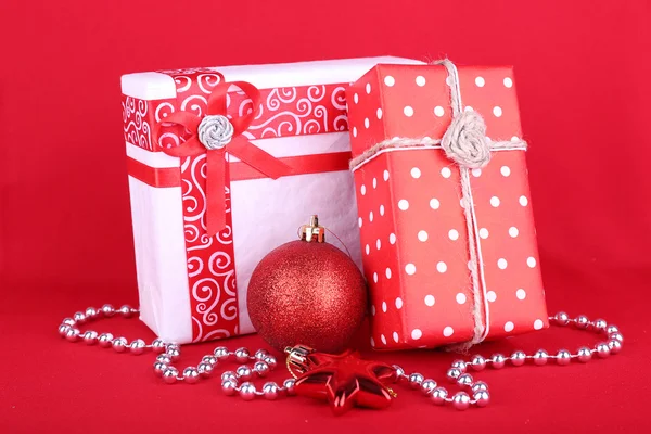 Beautiful bright gifts and Christmas decoration on red background Stock Picture