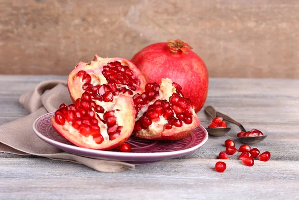 Beautiful composition with juicy  pomegranates, on old wooden table — Stock Photo, Image