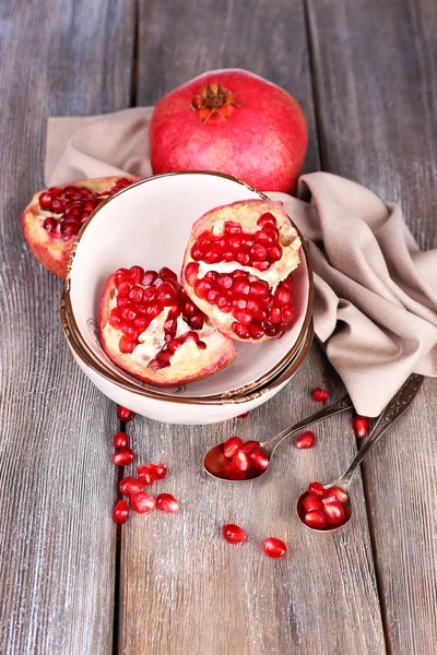 Krásná kompozice s šťavnatými granátovými jablky, na starém dřevěném stole — Stock fotografie