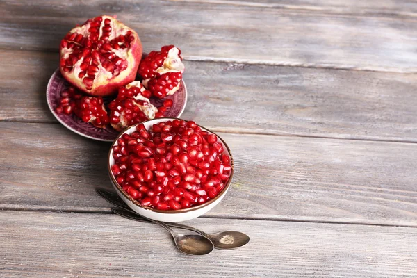 Mooie compositie met sappige granaatappel zaden, op oude houten tafel — Stockfoto