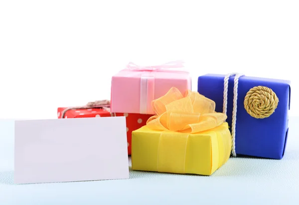 Boîtes colorées avec carte de vœux sur fond bleu inégal — Photo