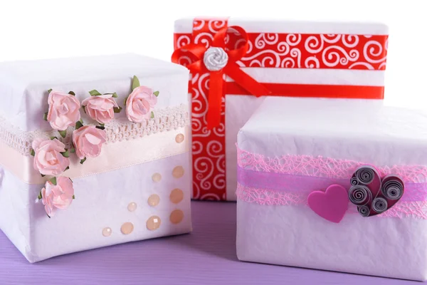Tre scatole regalo bianco carino sulla superficie viola isolato su bianco — Foto Stock