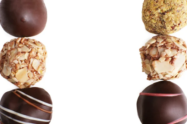 Lijnen van geassorteerde chocolade snoepjes op een witte achtergrond — Stockfoto